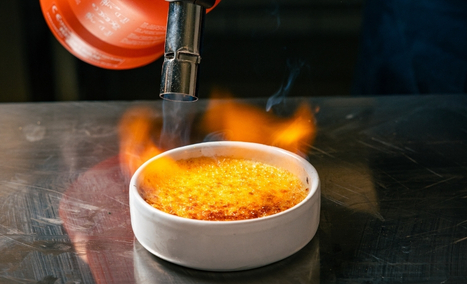 Caramelisation au chalumeau d'une crème brûlée maison au restaurant Les Gaillards. à Vannes.