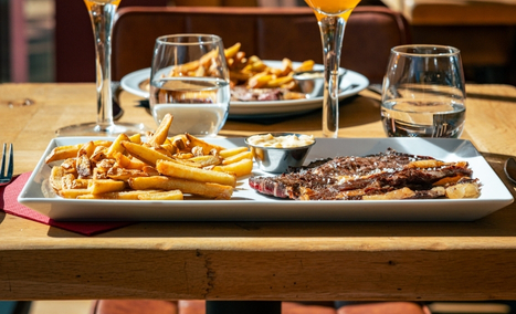 Assiette de steak grillé au feu de bois et frites maison sur une table du restaurant Les Gaillards. à Vannes.